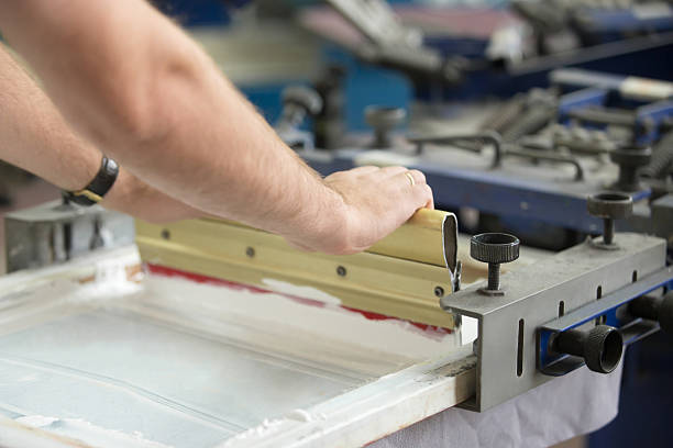close-up of male hands working with squeegee - print shop imagens e fotografias de stock