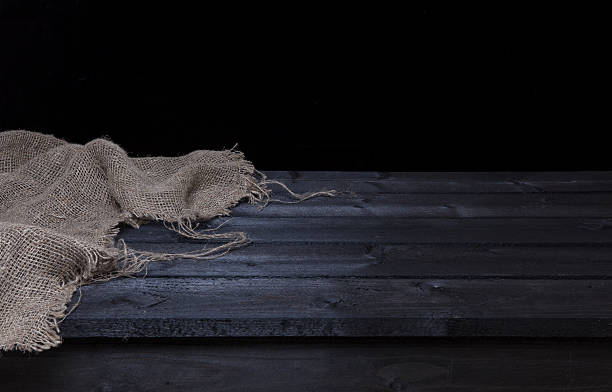Dark black wooden table with burlap for product display montage