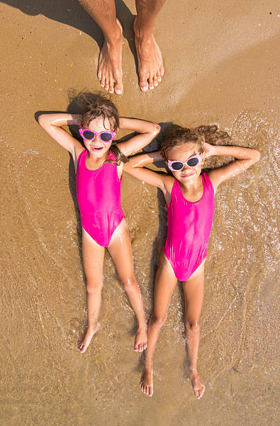 istock Two girls lie on his back on the surf of 626059738