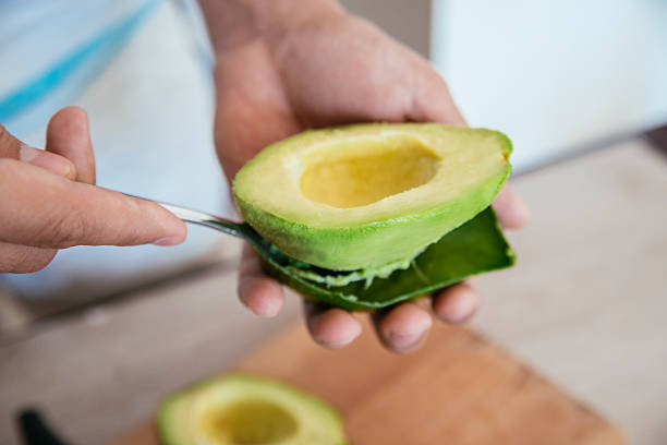 Fresh Avocado Fresh Avocado Getting Peeled With A Spoon ripe stock pictures, royalty-free photos & images