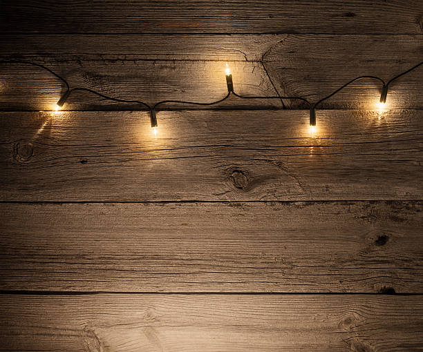istock Christmas lights on wooden background 626067166