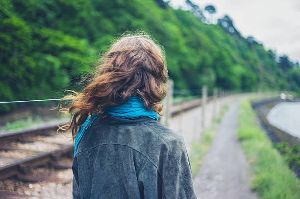 istock Young woman by railroad tracks 626071702
