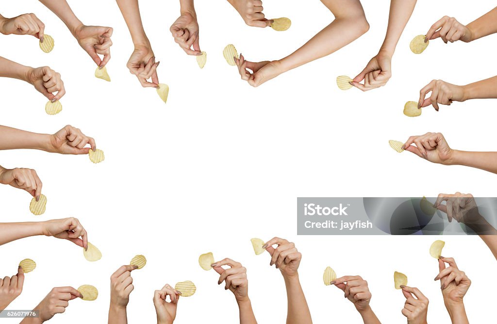 hand holding chips background image of many woman hands holding a single crisp in each hand Potato Chip Stock Photo