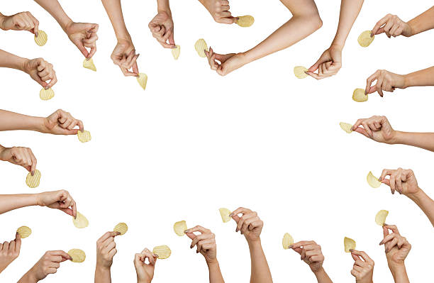 hand holding chips background image of many woman hands holding a single crisp in each hand potato chip stock pictures, royalty-free photos & images