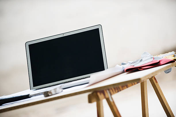 istock Blueprints, laptop, and safety gloves on table 626072666
