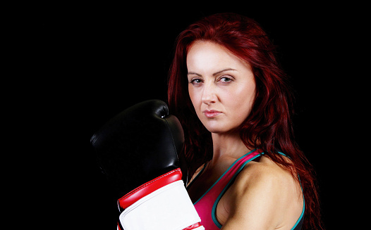 beautiful woman wearing boxing gloves,black background