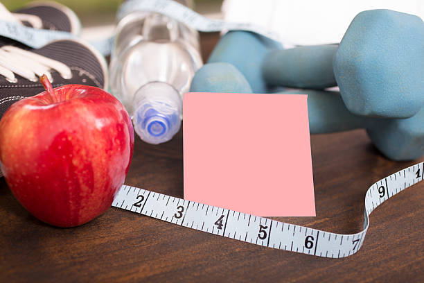 istock Fitness, exercise themed scene with weights, running shoes, apple. 626074338