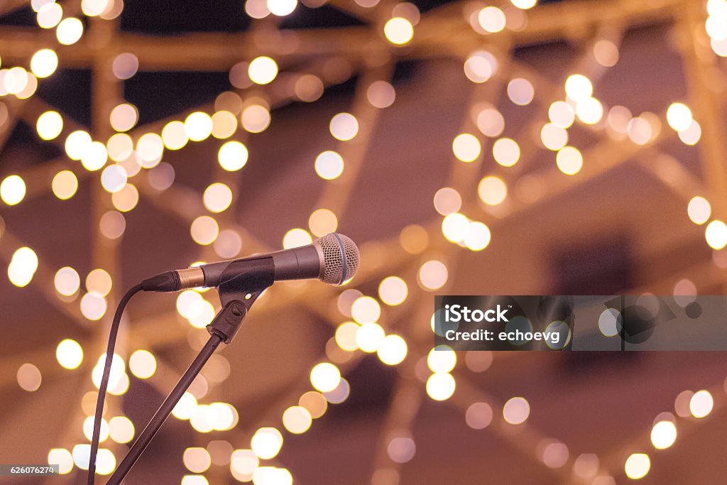 Microphone on stand with smooth soft warm light bokeh background Microphone on stand with smooth soft warm light bokeh background in orange yellow and pink. Concept for live performance, stage, artist, musician, singer, happy times, fun, joy. Awards Ceremony Stock Photo