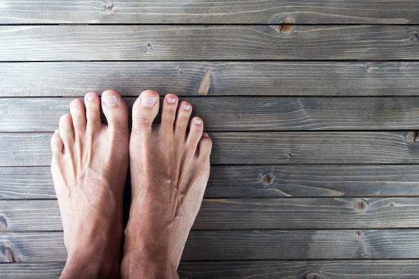 pies masculinos sobre fondo de madera. - wood rustic close up nail fotografías e imágenes de stock