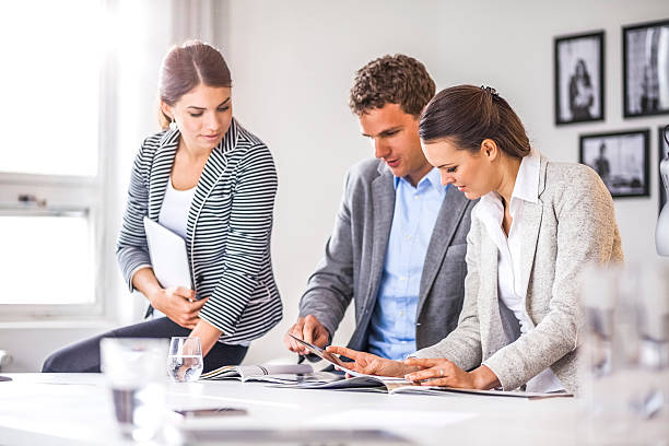 istock Young business people discussing over brochure at office desk 626078498