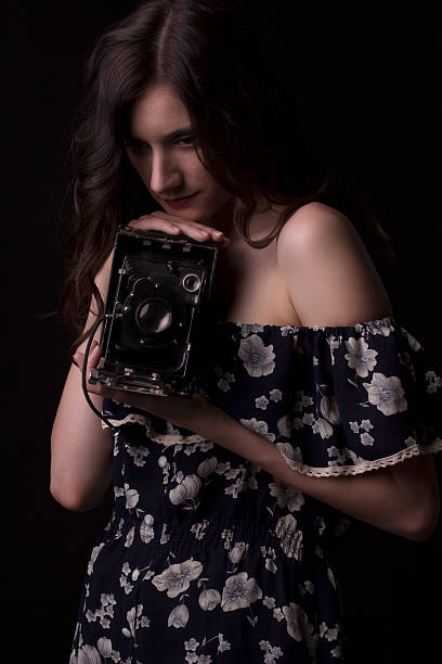 Young woman photographer with old camera