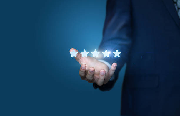 istock Businessman hand holding five stars isolated on blue background 626085480