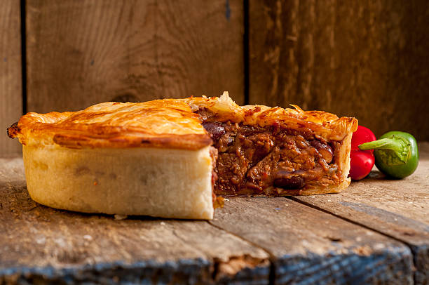 Sliced Meat Pie with Peppers Sliced meat pie alongside red and green peppers. meat pie stock pictures, royalty-free photos & images