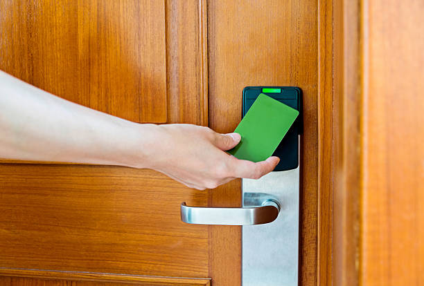 Woman unlocking the hotel room door with keyless entry card.