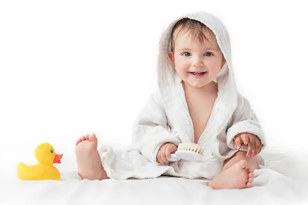 Photo of Little baby smiling under a white towel, bath time concept