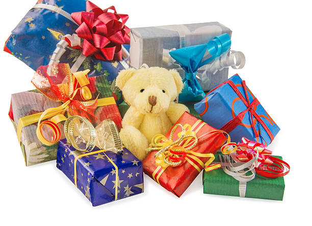 istock Teddy bear sitting with heap of gift boxes on white. 626090716