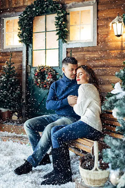 Photo of Lovers embracing on a background of their house