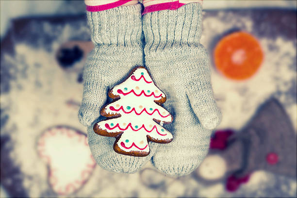 istock Child hands in gloves holding gingerbread cookie 626096056