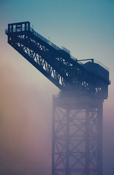 grue industrielle au lever du soleil dans le brouillard - crane shipyard construction pulley photos et images de collection