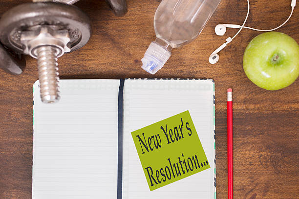 istock Fitness, new year's resolution scene with weights, earbuds, apple, calendar. 626098700