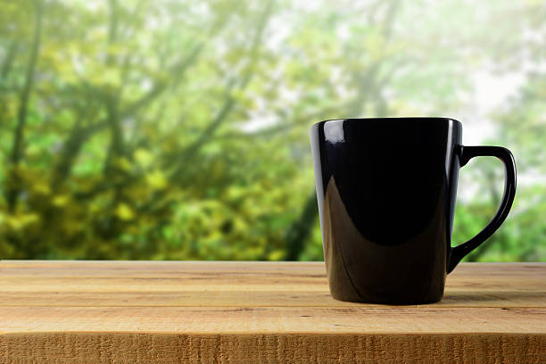 istock Black mug on wooden and blur background. 626098998