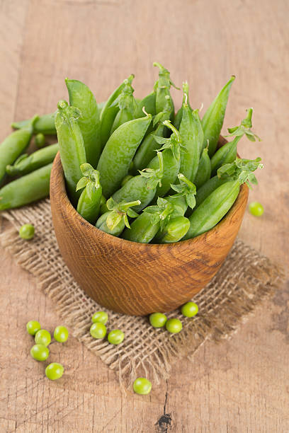 istock fresh pea pods in a wooden bowl 626099542