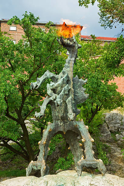 Statue of fire breathing dragon Krakow, Poland - September 2, 2016: Statue of a fire breathing dragon near the Wawel castle. wawel cathedral stock pictures, royalty-free photos & images