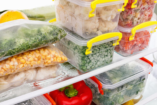 Alimentos congelados en el refrigerador. Verduras en los estantes del congelador. photo