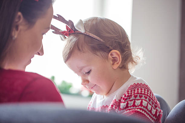 Christmas is a beautiful day happy family mother and little daughter playing in Christmas.Reindeer antlers and oily on their heads.Behind  Christmas and New Year decorations.Mother and  daughter enjoying the holidays at home baby new years eve new years day new year stock pictures, royalty-free photos & images