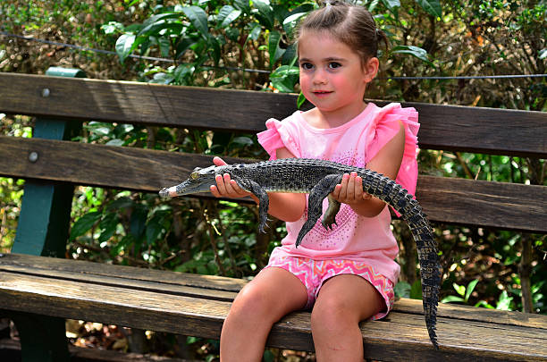 Girl holds a baby alligator