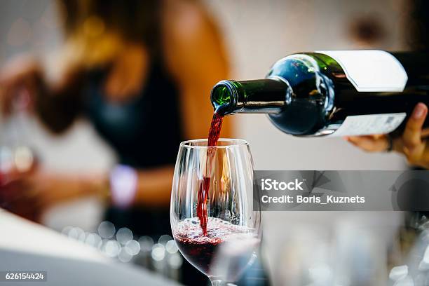 Verter El Vino Tinto Foto de stock y más banco de imágenes de Vino - Vino, Botella de vino, Restaurante