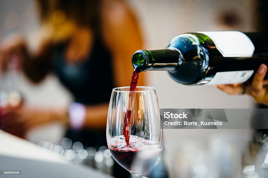 Pouring red wine. Man pouring red wine to wine glass.  Wine Stock Photo