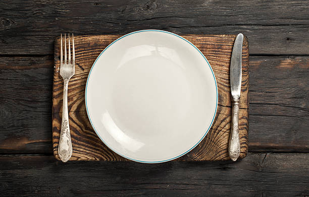 istock Empty plate with fork and knife on dark wooden background 626160718
