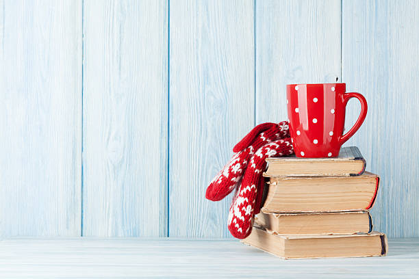 istock Hot chocolate cup and mittens over books 626173142