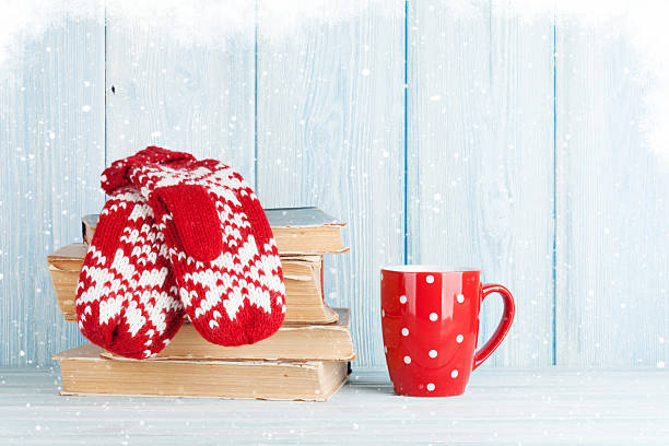 istock Hot chocolate cup and mittens over books 626173224