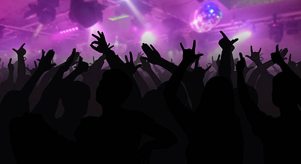 istock Silhouettes of concert crowd with hands raised 626174898
