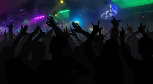 istock Silhouettes of concert crowd with hands raised 626174938