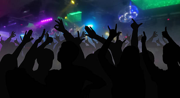 istock Silhouettes of concert crowd with hands raised 626174958