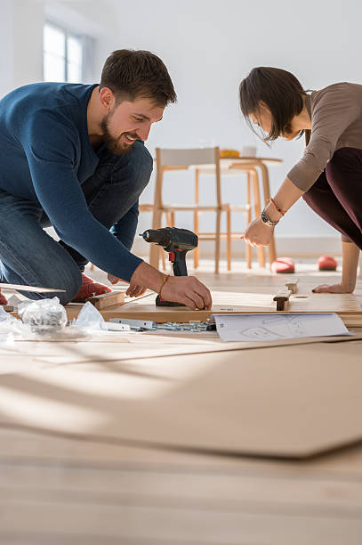 istock Couple assembling furniture in their new flat 626176062