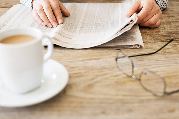 istock Reading newspaper on wooden table 626177716