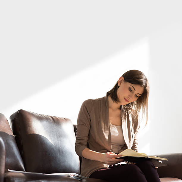 istock Young business woman planning while sitting on couch with notebook 626183098