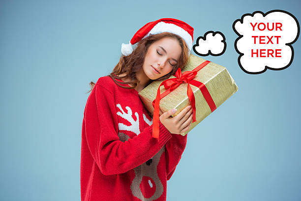 istock Girl dressed in santa hat with a Christmas gift 626183400