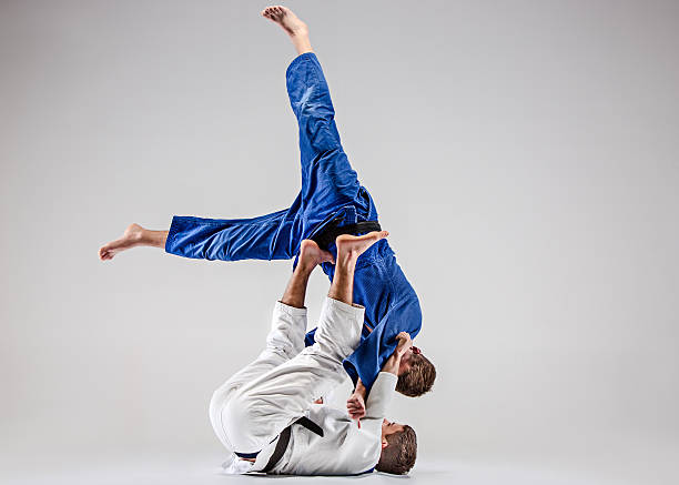 The two judokas fighters fighting men The two judokas fighters fighting men on gray studio background judo photos stock pictures, royalty-free photos & images