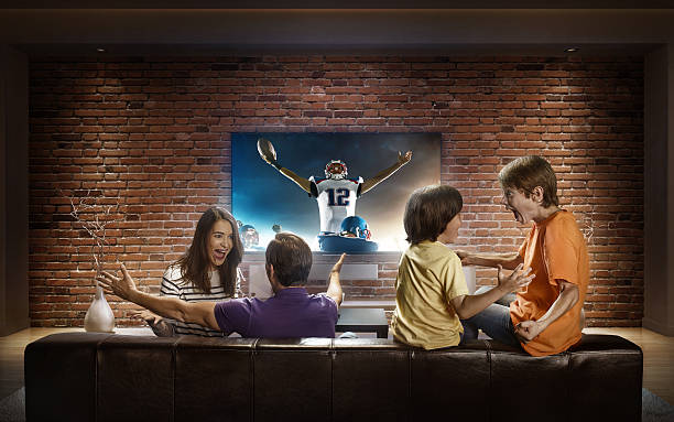 familia con niños viendo un partido de fútbol americano en la televisión - family television watching watching tv fotografías e imágenes de stock