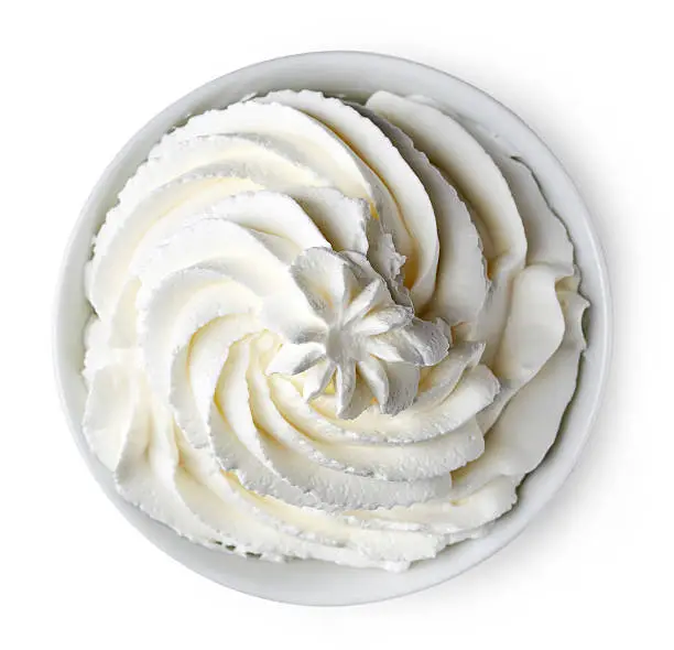 Bowl of whipped cream isolated on white background from top view