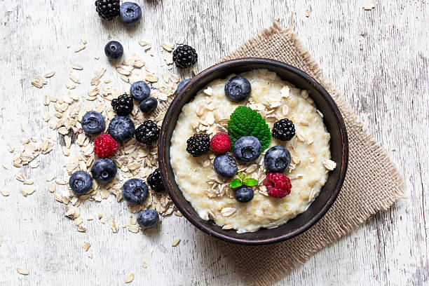 porridge di farina d'avena con bacche mature - porridge foto e immagini stock