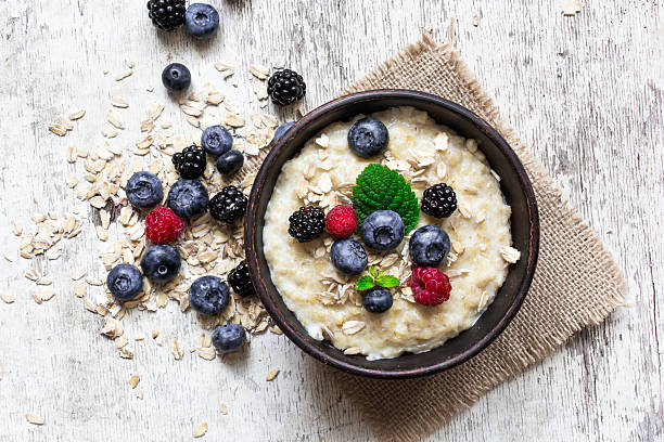 oatmeal porridge with ripe berries oatmeal porridge with ripe berries - blueberry, raspberry and blackberry for healthy breakfast. flat lay. top view dietary fiber photos stock pictures, royalty-free photos & images