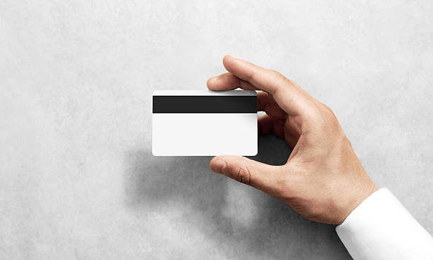 istock Hand holding blank white credit card mockup black magnetic stripe 626214230