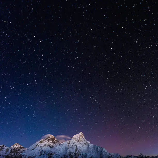 Stars shining above the iconic summit pyramid of Mt. Everest (8848m) and the snow capped mountain peaks of the Khumbu Himalaya deep in the Sargamatha National Park of Nepal, a UNESCO World Heritage Site.