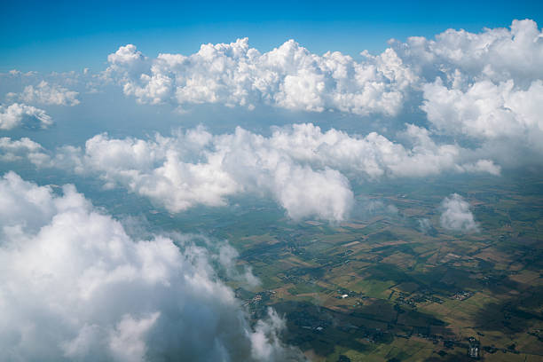 Landscape viewed from airplane Earth landscape viewed from airplane. Earth surface under the white clouds and blue sky from aerial view. Cloudy weather covering residential land and argriculture land. stratosphere airplane cloudscape mountain stock pictures, royalty-free photos & images